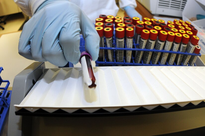 Petty Officer 3rd Class Matthew Hampton retrieves a vial from the rocking table, a machine that keeps the blood moving so it won’t coagulate. Depending on what tests a physician needs determines whether the blood will need to be clotted or not. Hampton is a Hospital Corpsman at Naval Health Clinic. (U.S. Navy photo/Petty Officer 1st Class Jennifer Hudson)