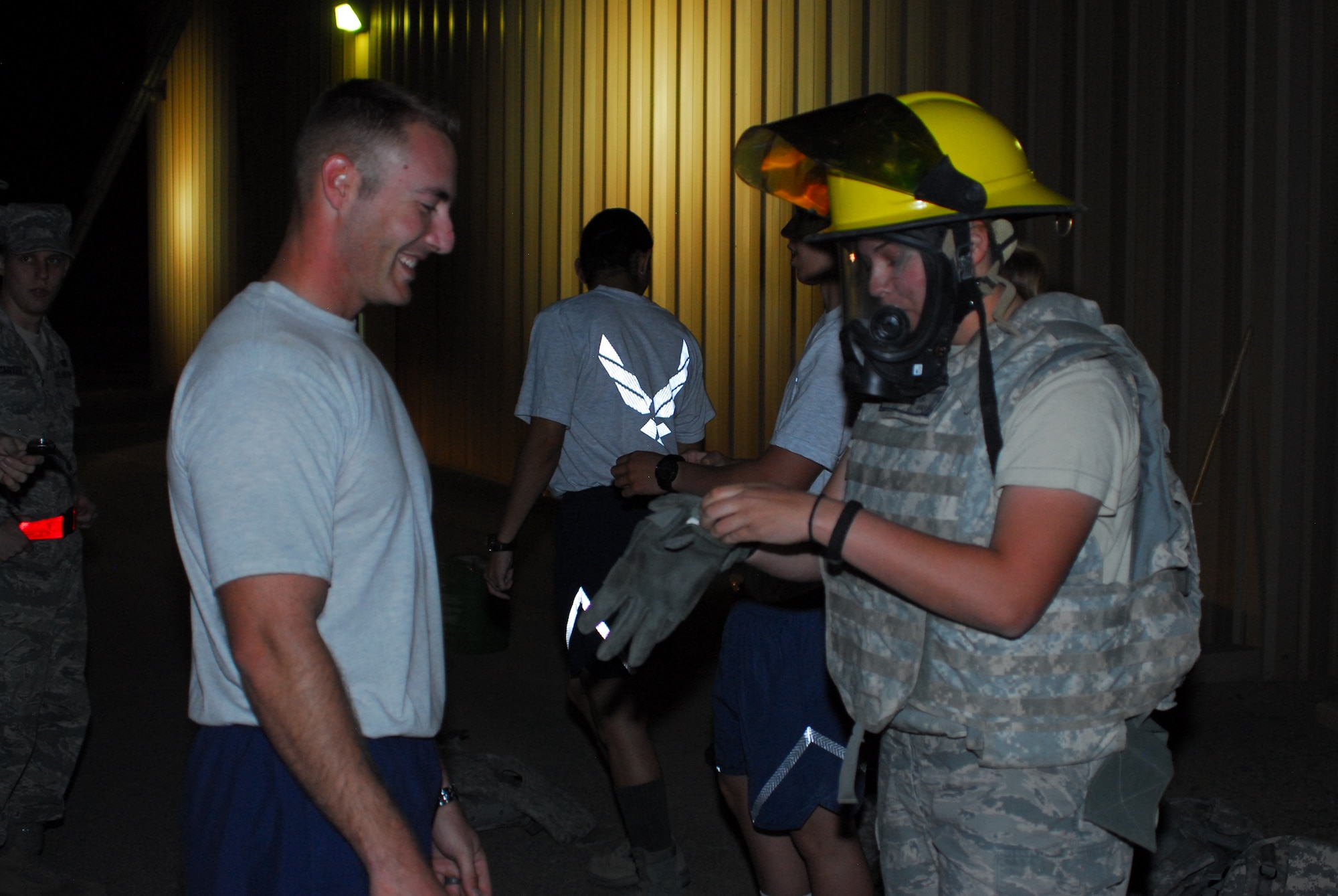Staff Sgt. Joshua Miles, 332nd Expeditionary Civil Engineer Squadron station captain, assists Airman 1st Class Riley Turnbull, 332nd Expeditionary Security Forces Squadron patrolman at a firefighter challenge at an undisclosed location in Southwest Asia Nov. 11, 2011. The timed event incorporated simulated situations encountered by first responders. Miles is deployed from Beale Air Force Base, Calif., and is a native of Waldorf, Md. Turnbull is deployed from Royal Air Force Lakenheath, United Kingdom, and is a native of Fair Oaks, Calif. (U.S. Air Force photo by 1st Lt. Rusty Ridley)