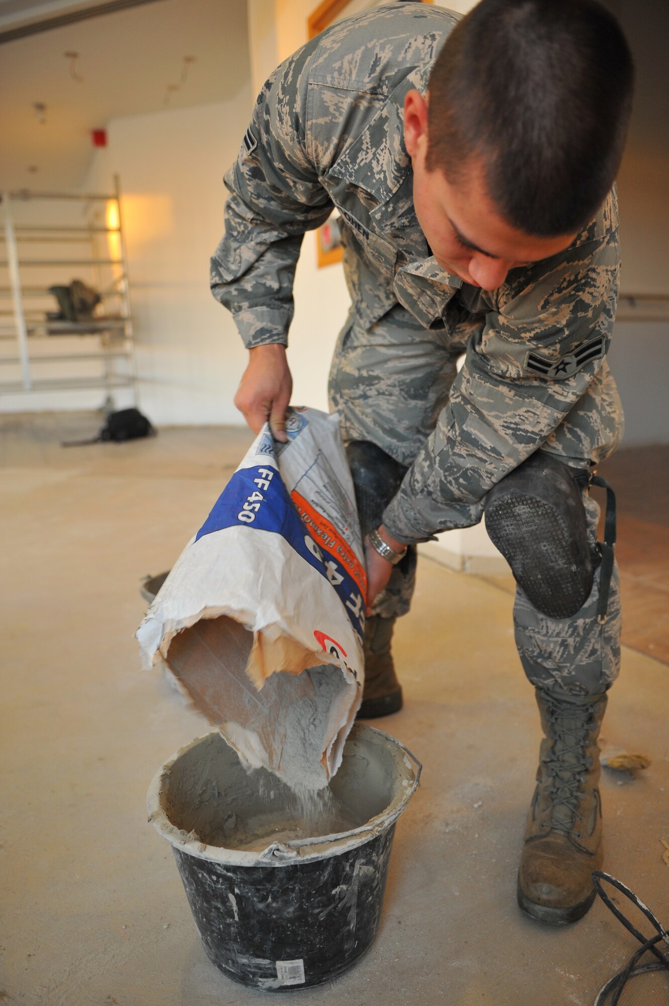 SPANGDAHLEM AIR BASE, Germany – Airman 1st Class Richard Cohen, 52nd Civil Engineer Squadron structures apprentice, pours flexible tile adhesive mix into a bucket inside the Mosel Dining Facility here Nov. 16. The 52nd CES is renovating the facility, to include, new flooring, paint, service line and storage facilities. Completion of the facility is scheduled for Jan. 15, 2012. (U.S. Air Force photo/Airman 1st Class Dillon Davis)