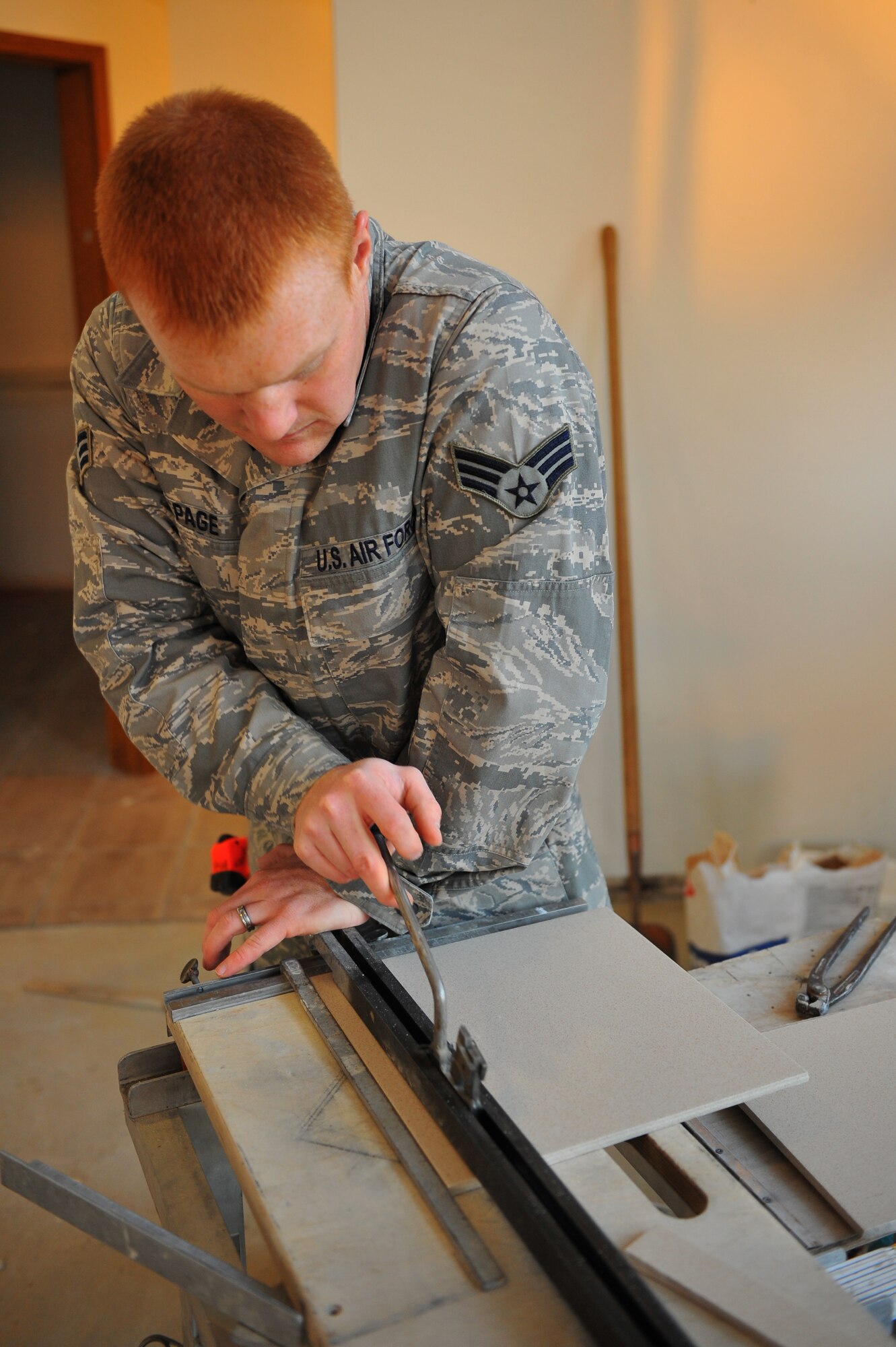 SPANGDAHLEM AIR BASE, Germany – Senior Airman Garth Page, 52nd Civil Engineer Squadron structures journeyman, cuts a tile inside the Mosel Dining Facility here Nov. 16. The 52nd CES is renovating the facility, to include, new flooring, paint, service line and storage facilities. Completion of the facility is scheduled for Jan. 15, 2012. (U.S. Air Force photo/Airman 1st Class Dillon Davis)