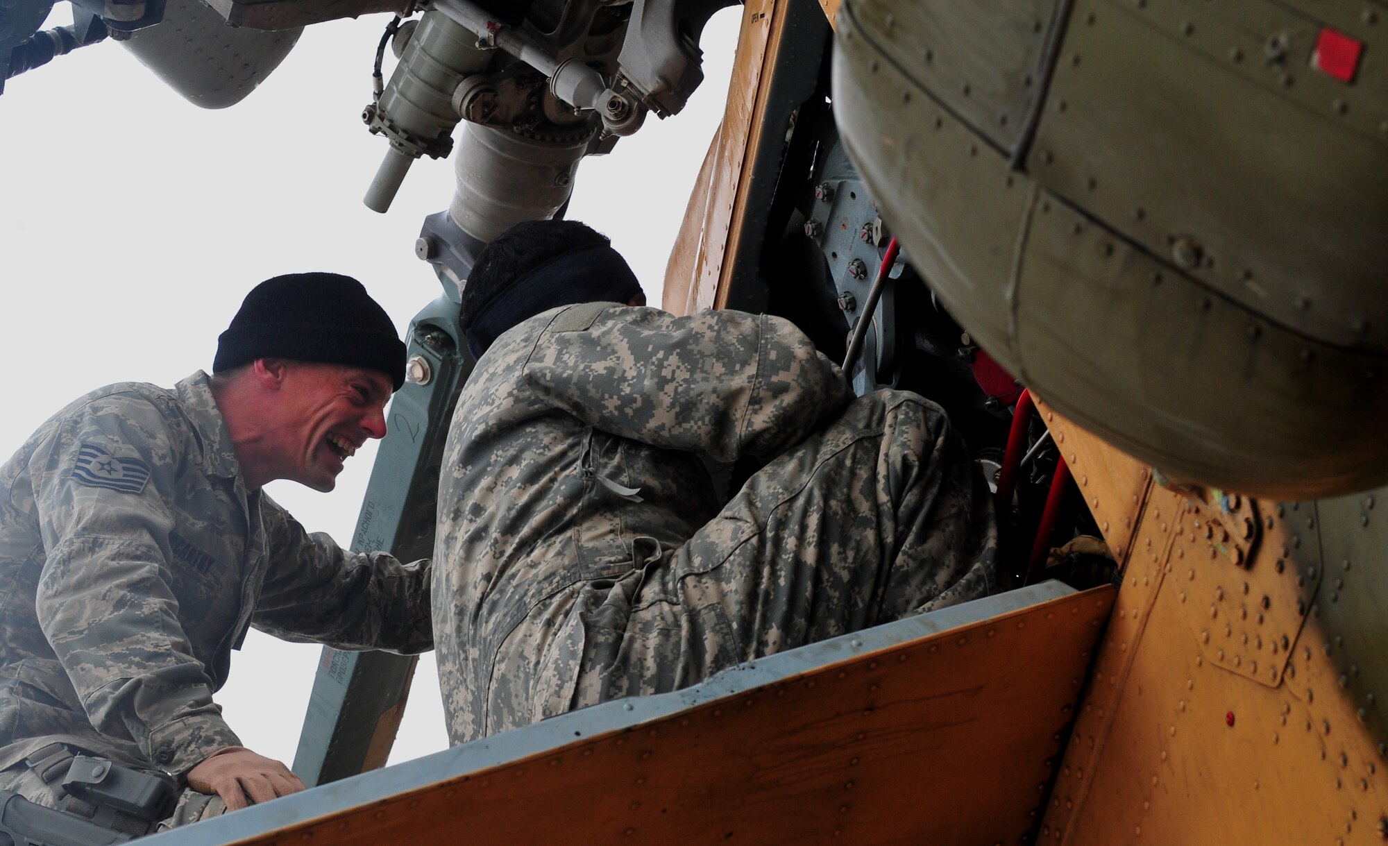Tech. Sgt. Keith McCarthy, 838th Air Expeditionary Advisory Group Detachment 1, maintenance air adviser, laughs with his Afghan counterpart during preflight checks before a training flight over Herat City, Afghanistan, Nov. 10, 2011. U.S. and Salvadoran airmen advise Afghan soldiers on maintenance, operations, and security of the Mi-17 helicopter. McCarthy is deployed from the 723th Aircraft Maintenance Sq. at Moody AFB, Ga. (U.S. Air Force Photo/SrA Tyler Placie)