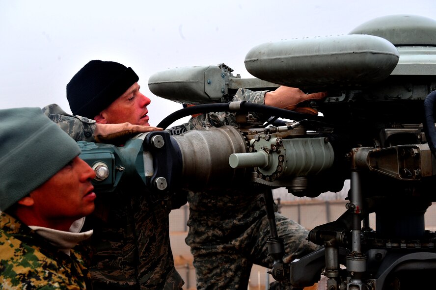 Tech. Sgt. Keith McCarthy, 838th Air Expeditionary Advisory Group Detachment 1, maintenance air adviser, works alongside a Salvadoran airman to complete preflight checks before a training flight over Herat City, Afghanistan, Nov. 10, 2011. U.S. and Salvadoran airmen advise Afghan soldiers on the maintenance, operations, and security of the Mi-17 helicopter.McCarthy is deployed from the 723th Aircraft Maintenance Sq. at Moody AFB, Ga. (U.S. Air Force Photo/SrA Tyler Placie)