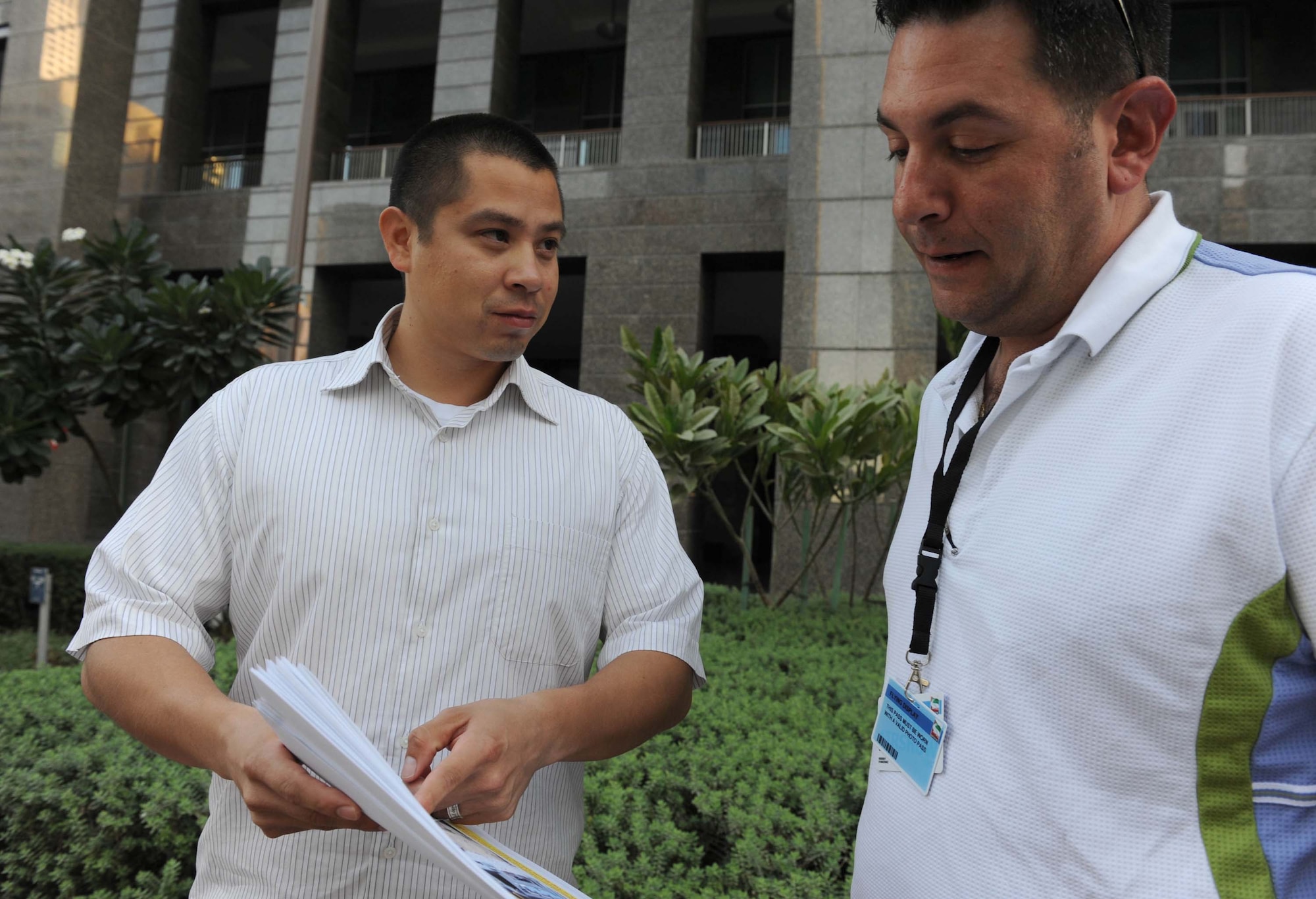 Tech. Sgt. David Morales, the vehicle operations supervisor for the 380th Expeditionary Logistics Readiness Squadron, discusses a transportation matter with Tech. Sgt. Ian Black, a contracting officer for the 380th Expeditionary Contracting Squadron, Nov. 12, 2011, during preparations for the Dubai Airshow 2011. Morales is deployed from Joint Base San Antonio, Texas.  (U.S. Air Force photo/Master Sgt. Chance Babin)