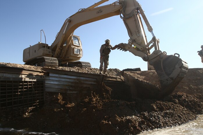 Cpl. Eric McMullen, a combat engineer with Alpha Company, Combat Logistics Battalion 1 and 21-year-old native of Lake Tahoe, Calif., checks the progress of a project here, Nov. 12. Marines of Alpha Co. are currently repairing the support structure on a bridge located at a major intersection that connects Marjah and Nawa districts. The bridge receives heavy foot and vehicle traffic due to the local bazaar, as well as Afghan and coalition military convoys.