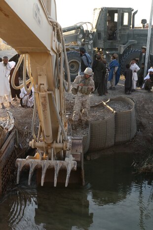 Cpl. Eric McMullen, a combat engineer with Alpha Company, Combat Logistics Battalion 1 and 21-year-old native of Lake Tahoe, Calif., checks the status of a culvert here, Nov. 12. Marines of Alpha Co. are currently repairing the support structure on a bridge located at a major intersection that connects Marjah and Nawa districts. The bridge receives heavy foot and vehicle traffic due to the local bazaar, as well as Afghan and coalition military convoys.::r::::n::