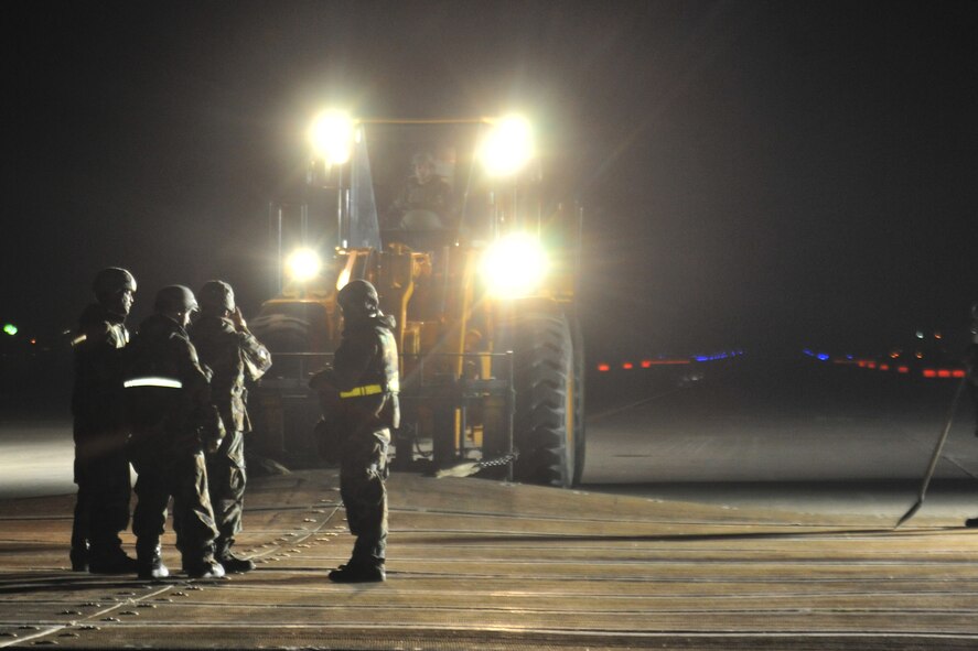 Airmen from the 8th Civil Engineer Squadron airfield damage repair team prepare a crater cover mat during exercise Beverly Bulldog 11-3, at Kunsan Air Base, Republic of Korea, Nov. 17, 2011. ADR teams do everything from crater repair to airfield lighting making it possible to get aircraft back in the air quickly. (U.S. Air Force photo by Senior Airman Brittany Y. Auld/Released)