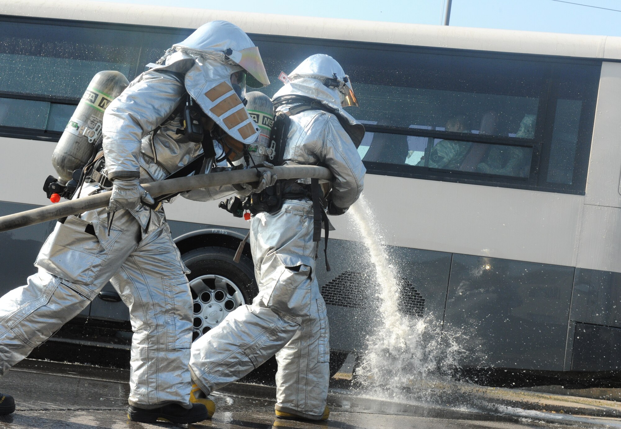 Firefighters with the 8th Civil Engineer Squadron respond to a simulated burning bus as part of operational readiness exercise Beverly Bulldog 11-3, Nov. 1, 2011.  The scenario was planned and evaluated by several exercise evaluation team members who tested the Airmen’s ability to quickly and safely respond to the incident. As part of the scenario, opposition forces ambushed the bus and caused it to crash into the base post office. The exercise is part of a peninsula wide operation, which tests Airmen and Soldiers' ability to respond and defend the area during wartime conditions. (U.S. Air Force photo by Senior Airman Jessica Hines/Released)