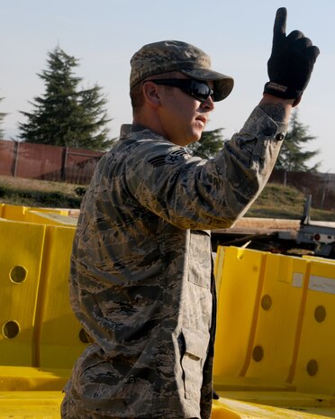 Senior Airman Daniel Bailey, 9th Cilvil Engineer Squadron pavement and construction journeyman, directs a forklift operator on Beale Air Force Base, Calif., November 16, 2011. Bailey loaded barricades onto the forklift to be moved back into their original place. (U.S. Air Force photo by Senior Airman Sandra Healy)