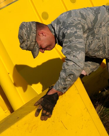 Senior Airman Ryan Purdy, 9th Civil Engineer Squadron pavement and construction journeyman, pushes a barricade into place at Beale Air Force Base, Calif., November 16, 2011. The barricades were moved in order to level the ground it was housed on. (U.S. Air Force photo by Senior Airman Sandra Healy)