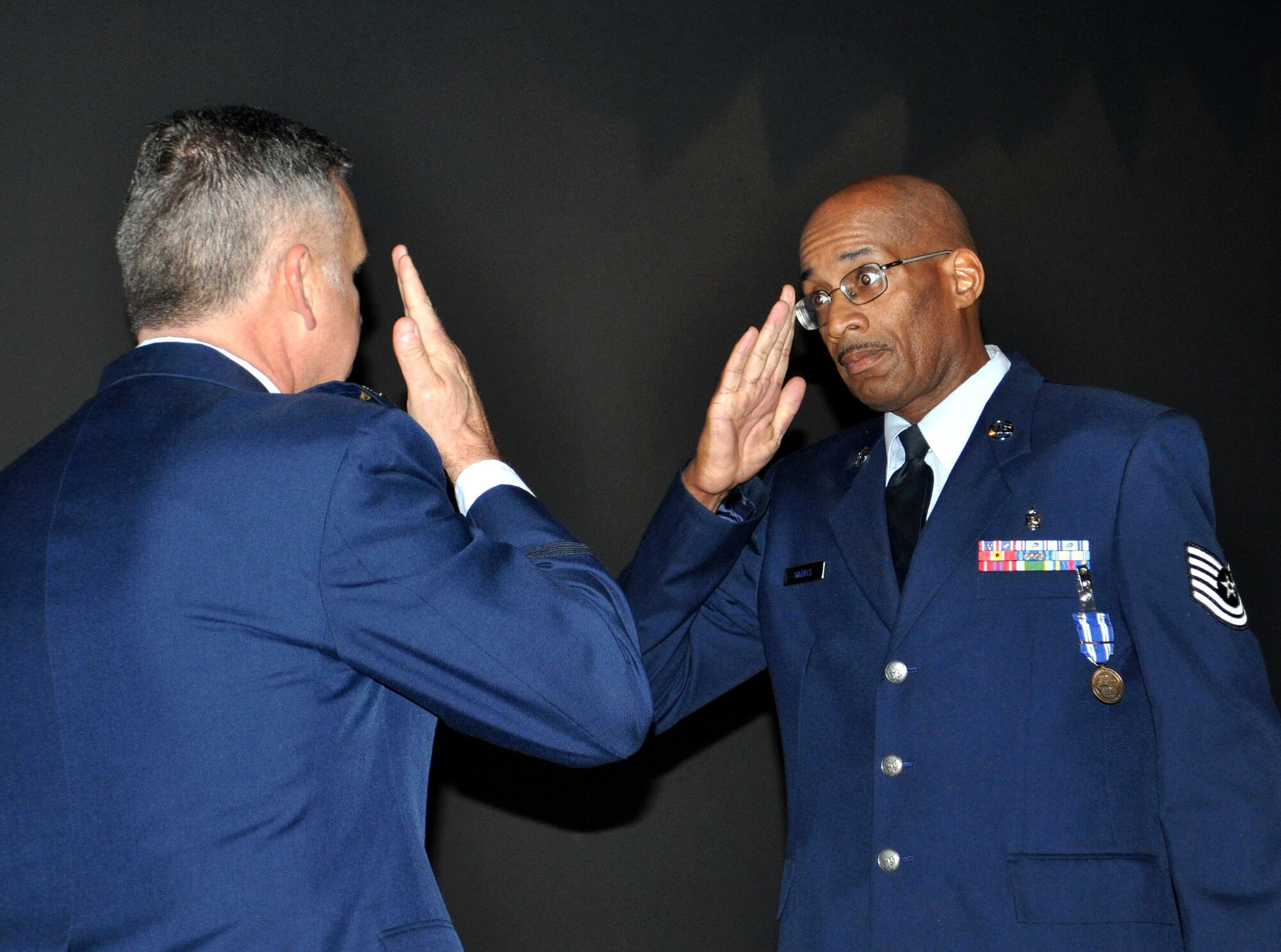 TRAVIS AIR FORCE BASE, Calif. -- Tech. Sgt. Michael Harris, 349th Aeromedical Staging Squadron, returns a sharp salute to 349th Air Mobility Wing Commander, Col. Jay Flournoy, at a Nov. 6, 2011 Commander's Call. Harris was awarded the North Atlantic Treaty Organization medal (NATO) for his performance while deployed recently. (U.S. Air Force photo/Staff Sgt. Rachel Martinez).