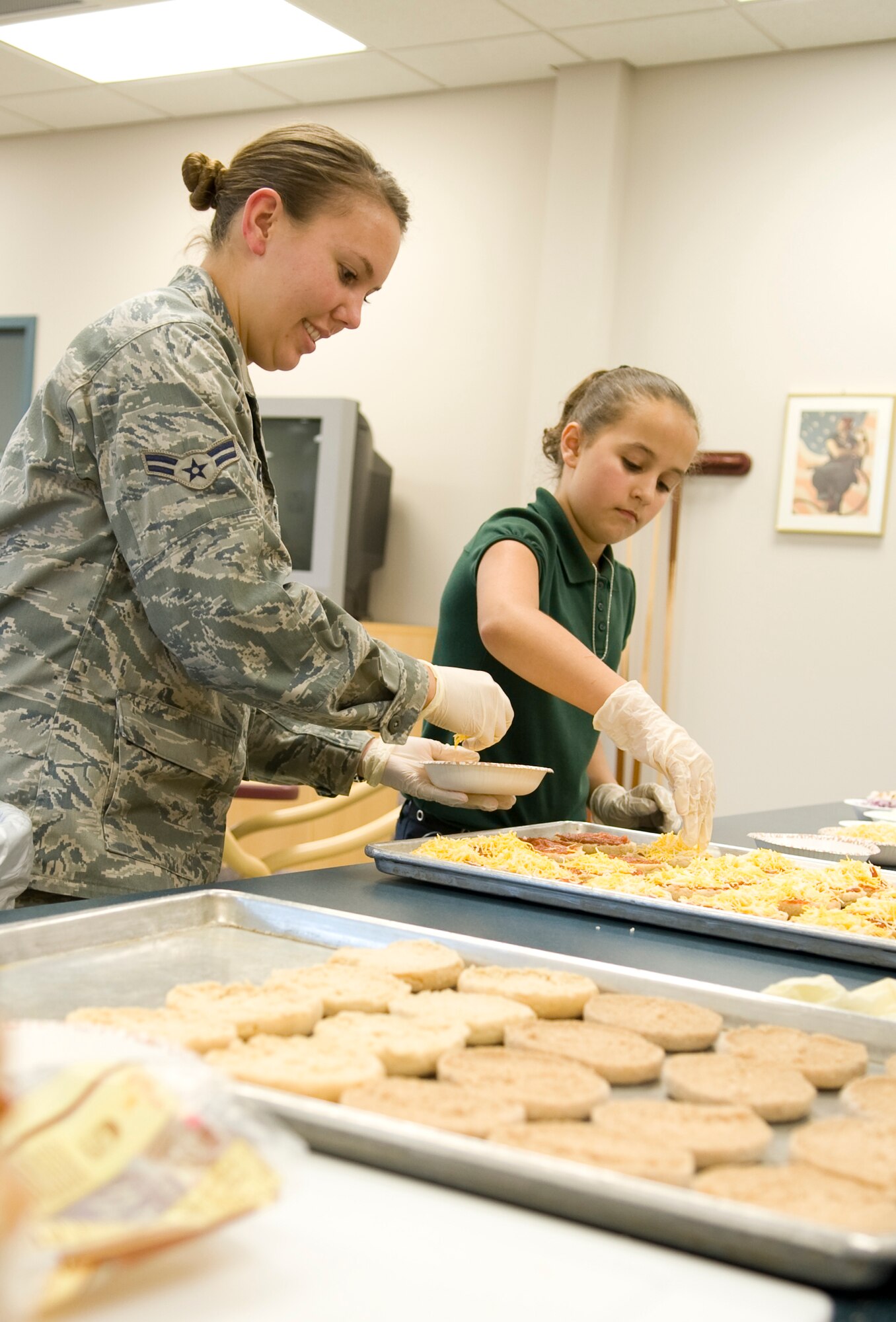 Airman 1st Class Andrea Liechti, 2nd Bomb Wing Public Affairs, and Miranda McCann, 9, daughter of Senior Airman Benjamin McCann, 2nd Logistics Readiness Squadron, prepares pizza for Veterans during an activity at the Northwest Louisiana War Veterans home in Bossier City, La., Nov. 15. Members of Team Barksdale visited the veterans home as an opportunity to volunteer and spend time with the war heroes. (U.S. Air Force photo/Airman 1st Class Benjamin Gonsier)(RELEASED)