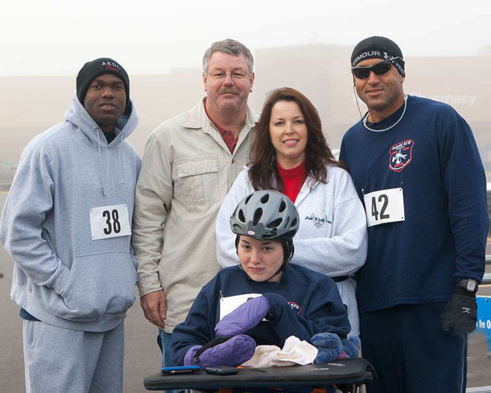 AEDC Firefighter Anthony Jimcoily, Firefighter Anthony Jimcoily, Firefighter/Crew Chief Dwane Kimmel, Kerry Kimmel and Assistant Fire Chirf George DeShields stand behind Victoria Atwell at the 5K race. (Photo by Kerry Kimmel Photography)
