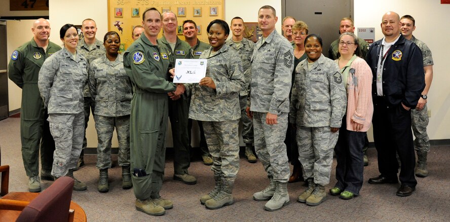 LAUGHLIN AIR FORCE BASE, Texas – Tech Sgt. Latisha D. Georges, 96th Flying Training Squadron knowledge operation management section chief, poses with Col. Thomas Murphy, 47th Flying Training Wing commander, after being presented the XLer of the week award here Nov. 9. The XLer is a weekly award chosen by wing leadership and given to those who consistently make outstanding contributions to Laughlin and their unit. (U.S. Air Force photo/Airman 1st Class Nathan L. Maysonet)