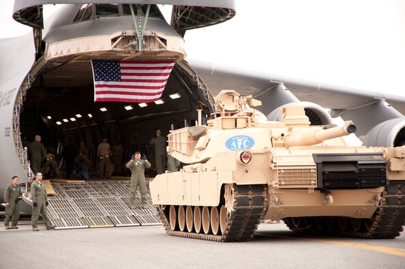 A loadmaster guides an M-1 Abrams tank into the C-5M Super Galaxy stationed at Dover Air Force Base, Del. The C-5M is capable of hauling two M-1 Abrams tanks to forward deployed location without requiring aerial refueling or en route stops. The C-5M recently flew the first-ever polar overflight mission for the Air Force, flying direct from Dover to Afghanistan. (U.S. Air Force photo by Lt. Col. Chad E. Gibson)
