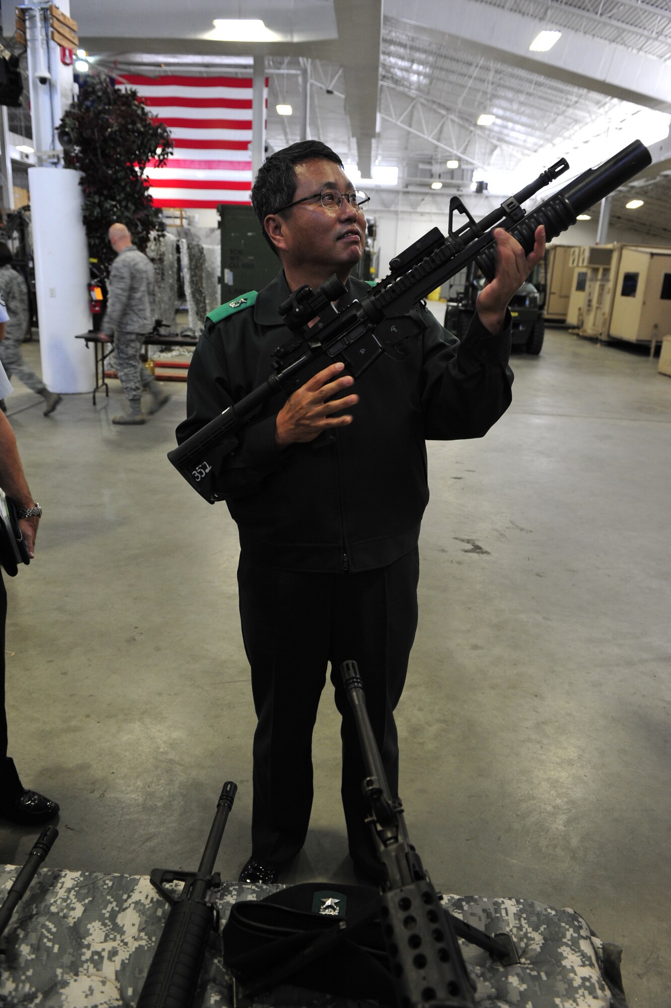 Brig. Gen. Gwi Chel Seo, commander of Transportation Command, Republic of Korea, holds an M4 carbine with an attached grenade launcher during a tour of the 621st Contingency Response Wing's Global Reach Deployment Center here Nov. 14.  General Seo and his staff spent the morning with the CRW, learning about Joint Task Force - Port Opening operations. (U.S. Air Force photo by Tech. Sgt. Parker Gyokeres/released)
