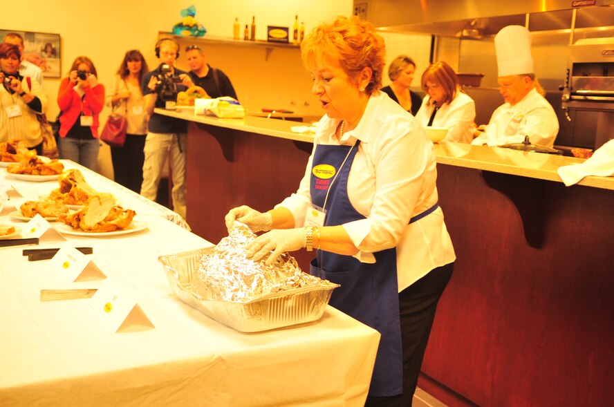 Marty Van Ness unwraps a cooked turkey for the students attending the Butterball University at the Butterball Headquarters in Garner, N.C., Nov. 15, 2011. Van Ness introduced a temporary storage method for turkeys, which included wrapping a fresh-out-of-the-oven turkey in alluminum foil, placing it in an ice cooler and placing towels on top. If the cooler remains unopened, a cooked turkey can maintain a safe temperature for two hours. (U.S. Air Force photo by Senior Airman Marissa Tucker) 