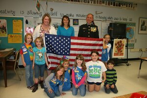 U.S. Marine Corps Maj. Jim Kokoszynskian American Legion and Veterans of Foreign War member, pose with Girl Scout Daisy Troop 60043 Oct. 24, 2011, at Highland Elementary School, Highland, N.Y. The girls are holding an American flag sent to them by U.S. Air Force Senior Master Sgt. Kevin Johnson, 366th Equipment Maintenance Squadron munitions materiel superintendent, in appreciation of care packages of Girl Scout cookies that were sent to his squadron during their recent deployment to Afghanistan. (Courtesy photo)