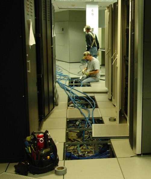 Larry Polen and Brian Crabtree from 88th Civil Engineer Division electric shop relocate power tails during power outage to replace aging equipment.  