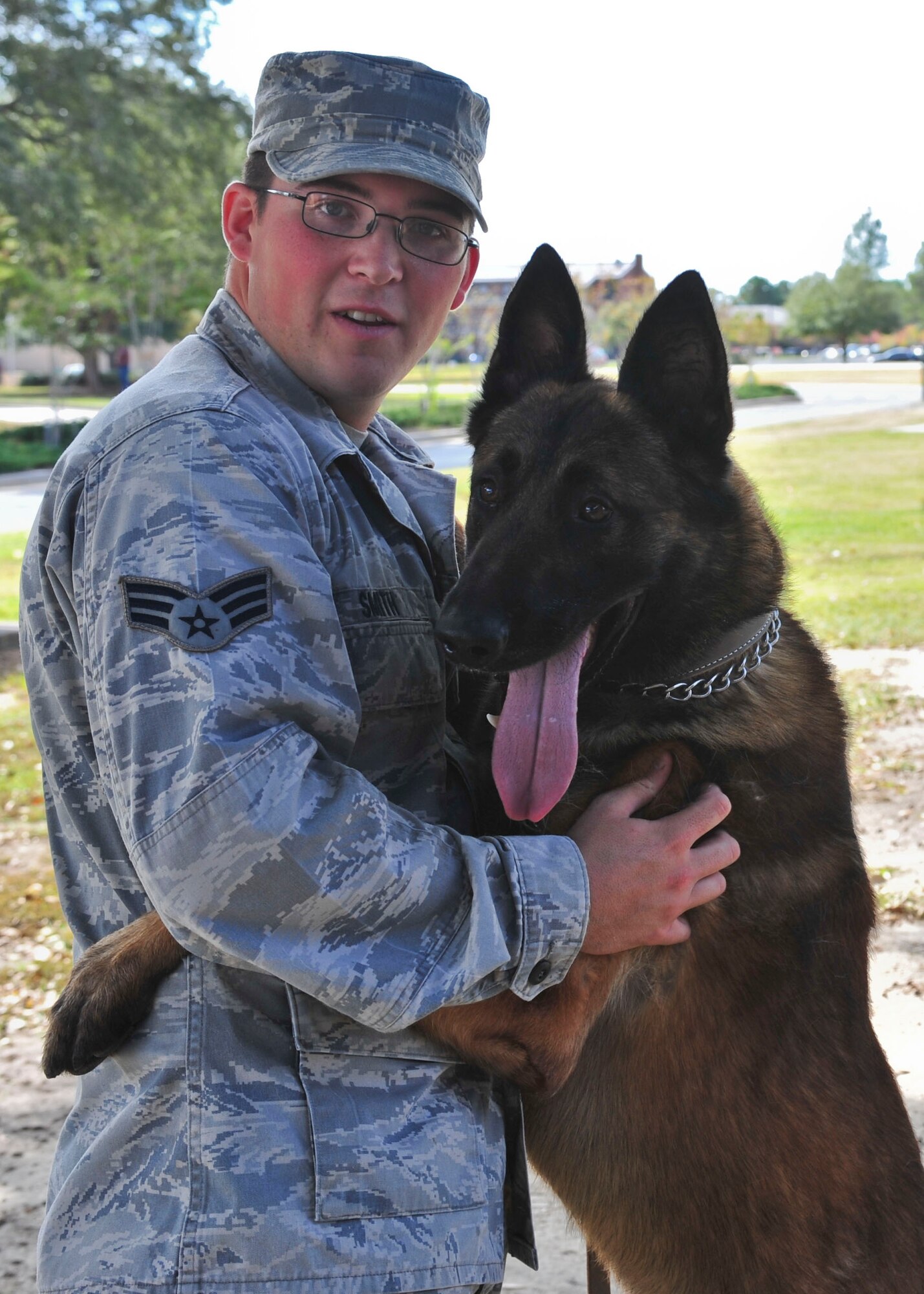 U.S. Air Force Senior Airman Erik Smith, 820th Combat Operations Squadron military working dog handler, and MWD Arco stand side-by-side at Moody Air Force Base, Ga., Nov. 7, 2011. Arco, a clear signal training dog, is Smith’s first MWD and Smith is Arco’s first handler. Smith completed a MWD handler course four months ago and was matched up with Arco who is two years and nine months old Belgian Malinois. (U.S. Air Force photo by Staff Sgt. Stephanie Mancha/Released)