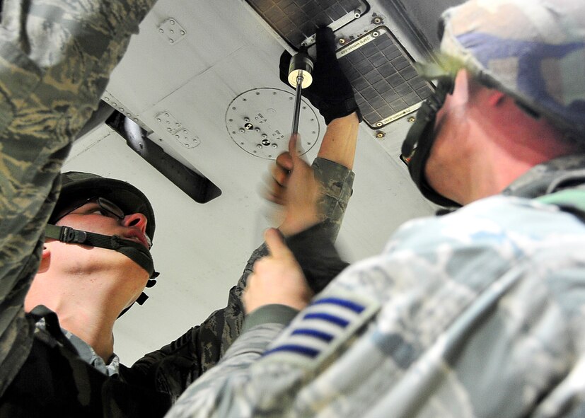 (Left) Senior Airman Douglas Howe, 51st Aircraft Maintenance Squadron weapons load crew member, holds a panel in place while Staff Sgt. Bryan Brown, 51st AMXS weapons load crew leader, screws in a screw   during Beverly Bulldog 11-03, a peninsula-wide operational readiness exercise Nov. 14, 2011. Beverly Bulldog 11-03 scenarios test team Osan’s ability to defend the base and conduct daily operations in a combat environment. (U.S. Air Force photo/Senior Airman Adam Grant)