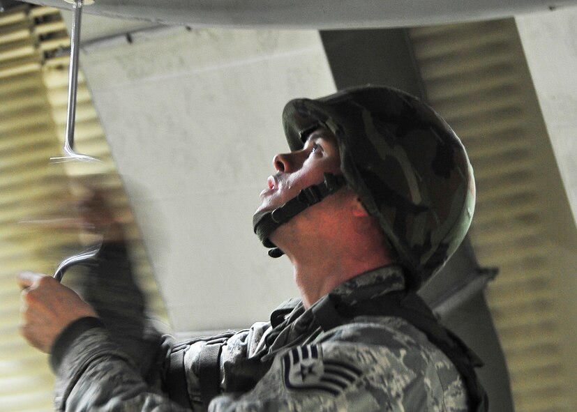 Staff Sgt. Bryan Brown, 51st Aircraft Maintenance Squadron weapons load crew leader, screws in a screw during Beverly Bulldog 11-03, a peninsula-wide operational readiness exercise Nov. 14, 2011. Beverly Bulldog 11-03 scenarios test team Osan’s ability to defend the base and conduct daily operations in a combat environment.  (U.S. Air Force photo/Senior Airman Adam Grant)