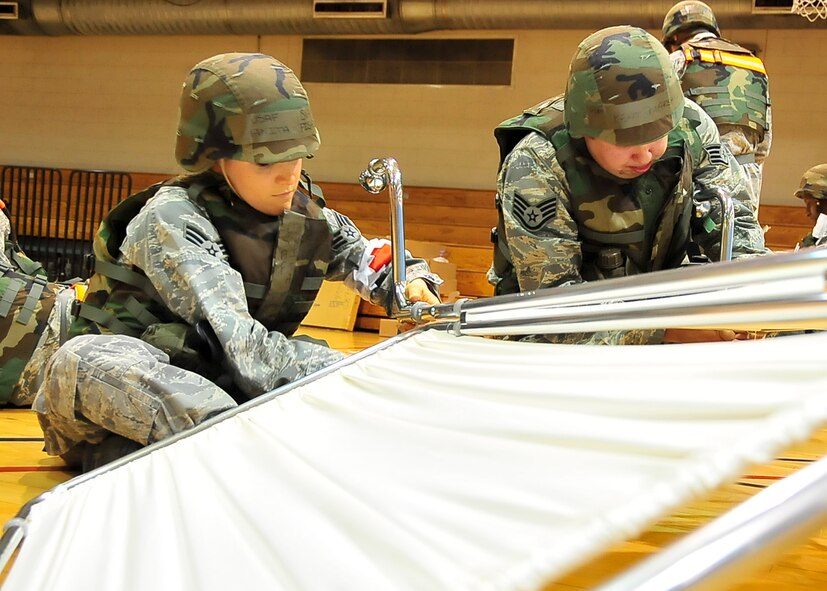 (Left) Senior Airman Anita Fisher, 51st Dental Squadron dental technician and Staff Sgt. Kent Marshall, 51st DS dental technician, put together blinds to ensure the privacy of patients during Beverly Bulldog 11-03, a peninsula-wide operational readiness exercise Nov. 13, 2011. Airmen are participating in a peninsula wide operational readiness exercise, Beverly Bulldog 11-03, held to train U.S. forces throughout South Korea. (U.S. Air Force photo/Senior Airman Adam Grant)
