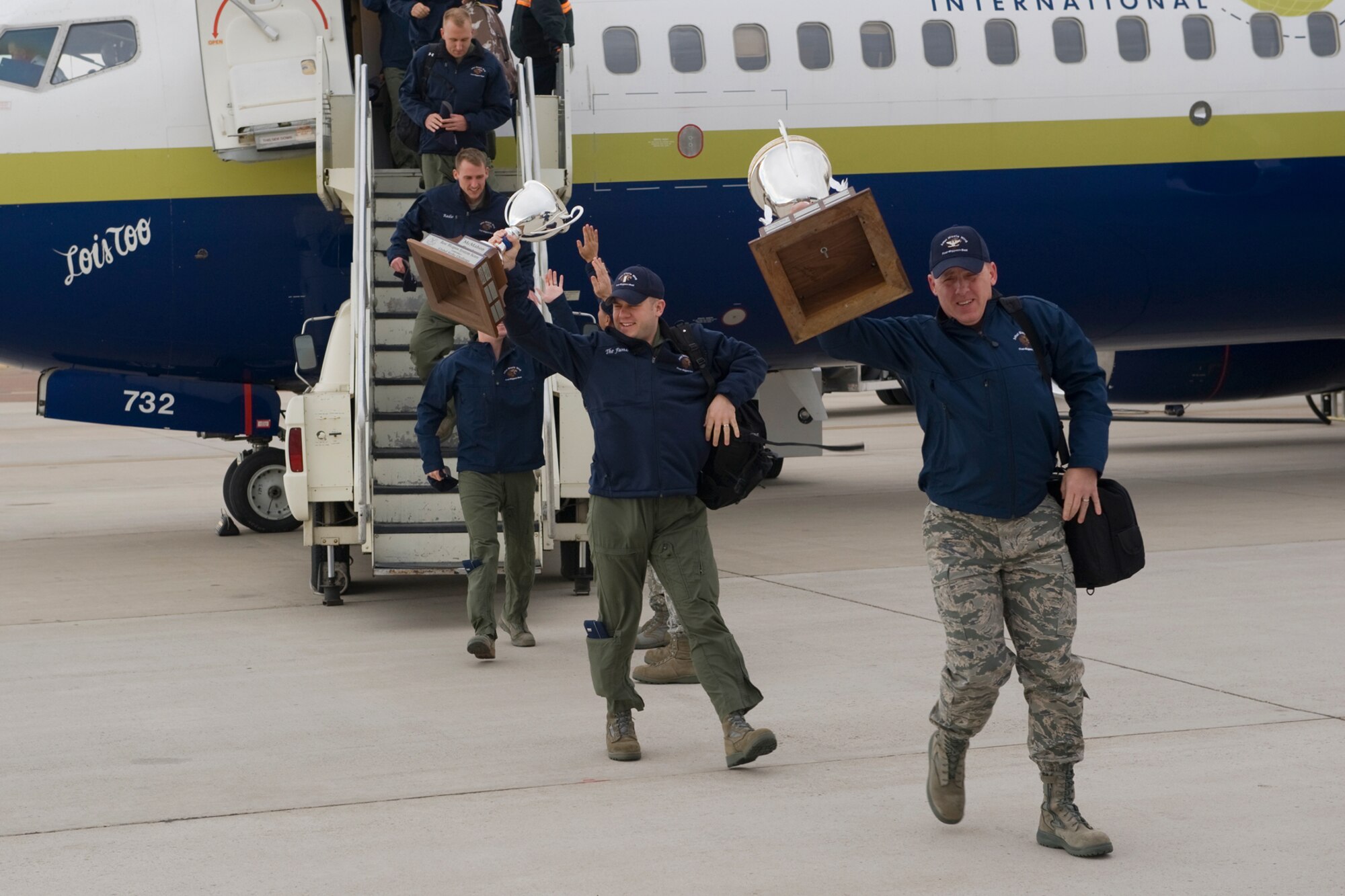 Col. Edward Rimback, 341st Operations Group commander, holds up the Klotz Trophy for Best ICBM Operations, as he leads his operators off the plane Nov. 10. Behind him is 1st Lt. John Malek, 490th Missile Squadron Global Strike Challenge competitor, holding the McMahon Trophy which was presented to the 490th team for Best Weapons System Operations. (U.S. Air Force photo/Beau Wade)