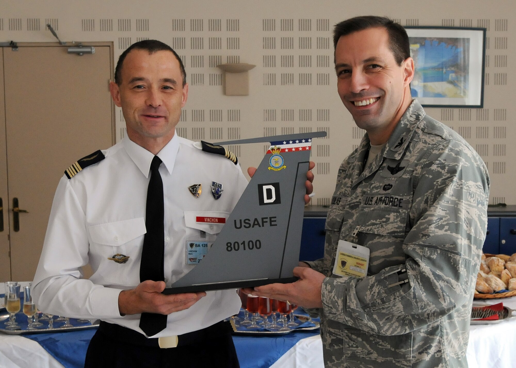 ISTRES, France – Col. Christopher Kulas, 100th Air Refueling Wing commander (right), presents French Air Force Col. Marc Vinchon, Base Aérienne 125 commander, with a Square D tail flash during a luncheon at BA 125, Istres, France, Nov. 8, 2011.  “This is about friendship, sharing and working together to ensure that we execute the mission,” said Kulas to the hosts. “Thank you for your support and cooperation that helped make this a great success.”  (U.S. Air Force photo/Staff Sgt. Tabitha M. Lee) 