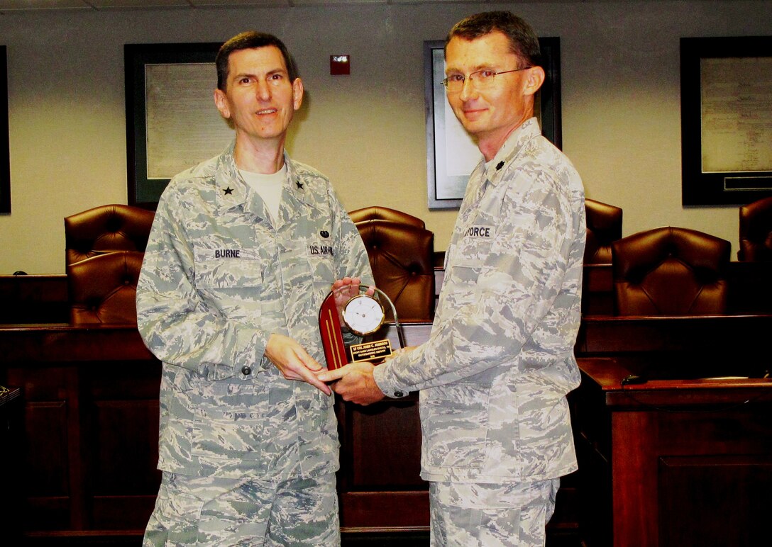 Brig. Gen. Christopher Burne, the Headquarters Air Combat Command Staff Judge Advocate. presents Lt. Col. John "Chris" Johnson, the 633rd Air Base Wing Deputy SJA, with the 2010 ACC Outstanding Deputy SJA of the Year Award at the Langley Law Center courtroom Nov. 2. Johnson's lengthy accomplishments include comprehensive management of joint base legal programs, successful awards package authoring, providing trusted legal counsel to base leadership, and selfless leadership in the law office, among other accolades.