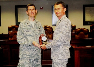 Brig. Gen. Christopher Burne, the Headquarters Air Combat Command Staff Judge Advocate. presents Lt. Col. John "Chris" Johnson, the 633rd Air Base Wing Deputy SJA, with the 2010 ACC Outstanding Deputy SJA of the Year Award at the Langley Law Center courtroom Nov. 2. Johnson's lengthy accomplishments include comprehensive management of joint base legal programs, successful awards package authoring, providing trusted legal counsel to base leadership, and selfless leadership in the law office, among other accolades.