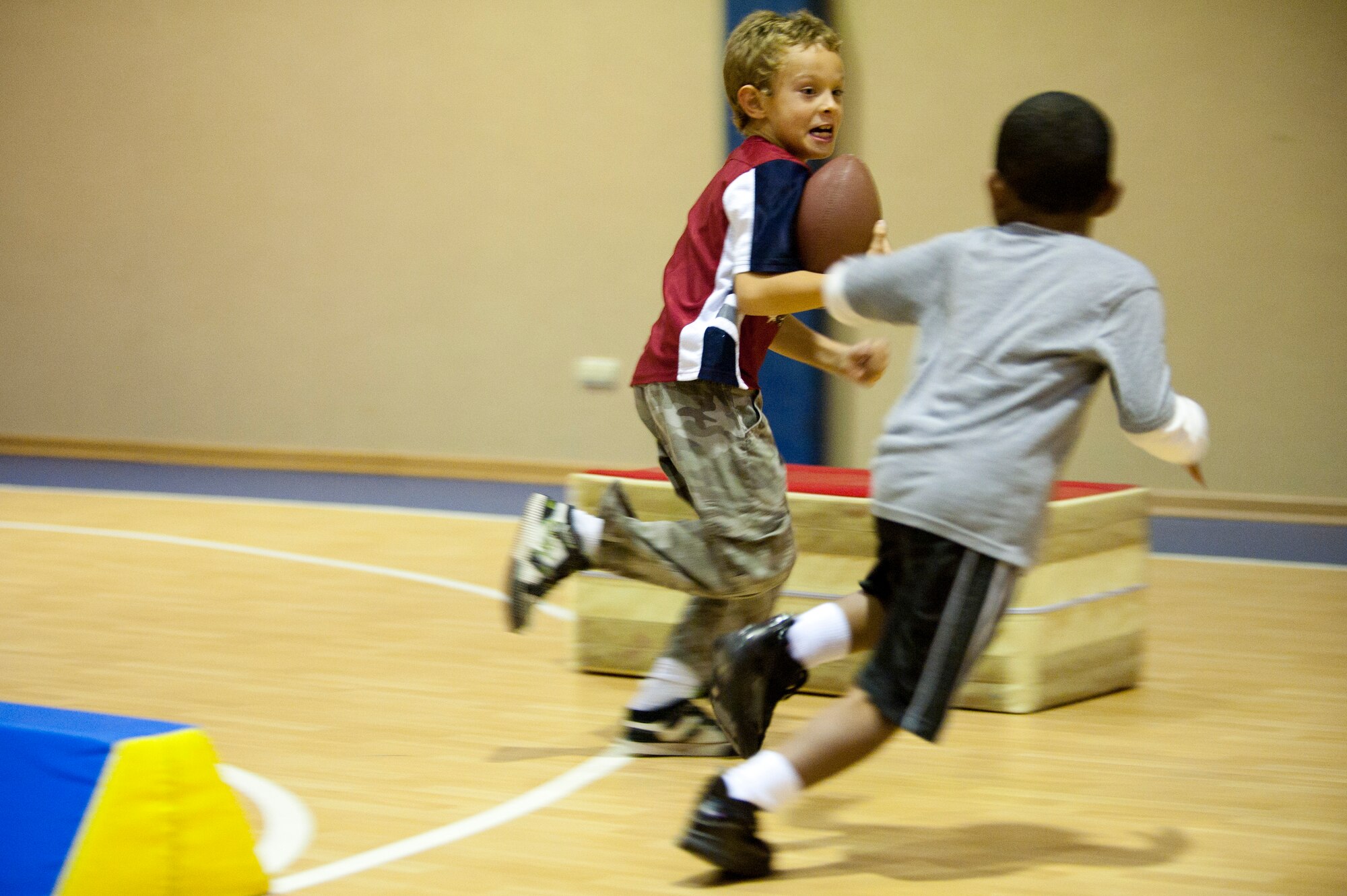 A child tries to evade a defender during a football mini-camp Nov. 16, 2011, at Incirlik Air Base, Turkey. The camp, hosted by the youth center, was held Nov. 14-18 in lieu of the youth football season and featured instruction on a variety of techniques for beginning players. (U.S. Air Force photo by Tech. Sgt. Michael B. Keller)