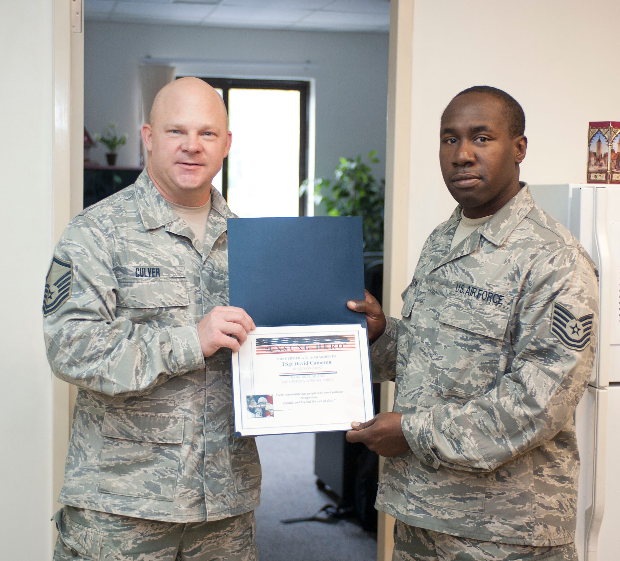 Tech. Sgt. David Cameron, 39th Logistics Readiness Squadron, receives the Unsung Hero Award from Master Sgt. Brett Culver, Incirlik Top 3, Nov. 16, 2011, at Incirlik Air Base, Turkey. The Top 3 presents this award monthly to Airmen who demonstrate superior job performance and exceptional leadership.(U.S. Air Force photo by Senior Airman Clayton Lenhardt/Released)
