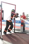 Staff Sgt. Roger Kemp, 4th Civil Engineer Squadron crew chief, breaks through a simulated door during the Scott World Firefighter Combat Challenge in Myrtle Beach, S.C., Nov. 15, 2011. Kemp completed the fourth leg of the relay by dragging the hose through a simulated door to put out a fire. Kemp hails from Chicago. (U.S. Air Force photo by Senior Airman Whitney Stanfield)