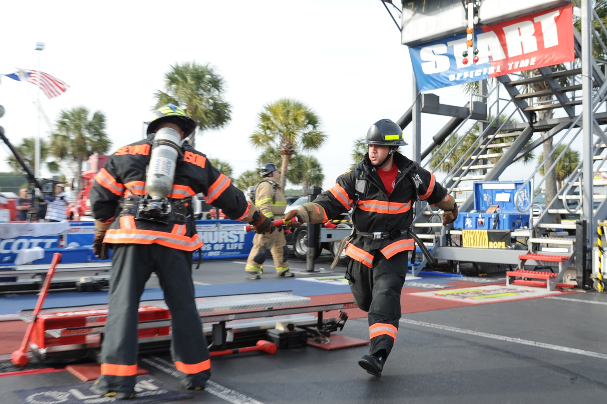 Robert Columbus, 4th Civil Engineer Squadron (CES) firefighter driver operator, passes a baton to Staff Sgt. Skipper Valentin-Cruzado during the Scott World Firefighter Combat Challenge in Myrtle Beach, S.C., Nov. 15, 2011. The baton has to be handed off to the next person before beginning the next leg of the relay. Columbus hails from Pittsburgh. Valentin-Cruzado is a 4 CES fire inspector and hails from Puerto Rico. (U.S. Air Force photo by Senior Airman Whitney Stanfield)