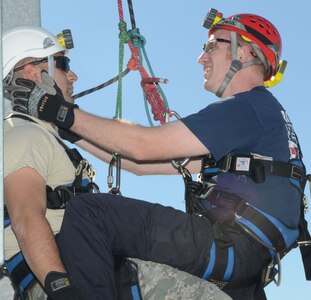 Staff Sgt. David Gamez, Randolph Fire Department fire services, plays role of the victim while Kenny Shepherd demonstrates rescue during the high angle and confined space training exercise held at Randolph Air Force Base, Texas on Nov. 16. (U.S. Air Force Photo by Don Lindsey)