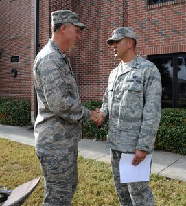 Maj. Gen. William Bender coins Capt. Jason Guadalupe after his brief about "Warrior Week" procedures for the upcoming Operational Readiness Inspection on Joint Base Charleston Nov.15. Bender is the Commander of the United States Air Force Expenditionary Center, Joint Base McGuire-Dix-Lakehurst, N.J. and Guadalupe is the Operations Officer of the 628th Force Support Squadron. (U.S. Air Force photo/Airman 1st Class Ashlee Galloway)