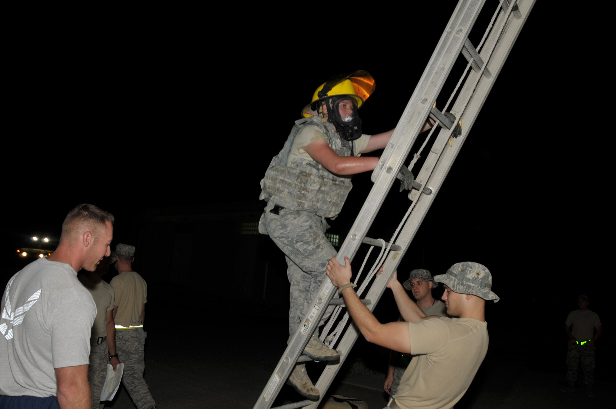 Airman 1st Class Riley Turnbull, 332nd Expeditionary Security Forces Squadron patrolman, deployed from Royal Air Force Lakenheath, United Kingdom, climbs a ladder during a firefighter challenge Nov. 11, 2011. Two spotters accompanied each participant to ensure safety requirements. (U. S. Air Force photo by Maj. Pamela S. Carroll)