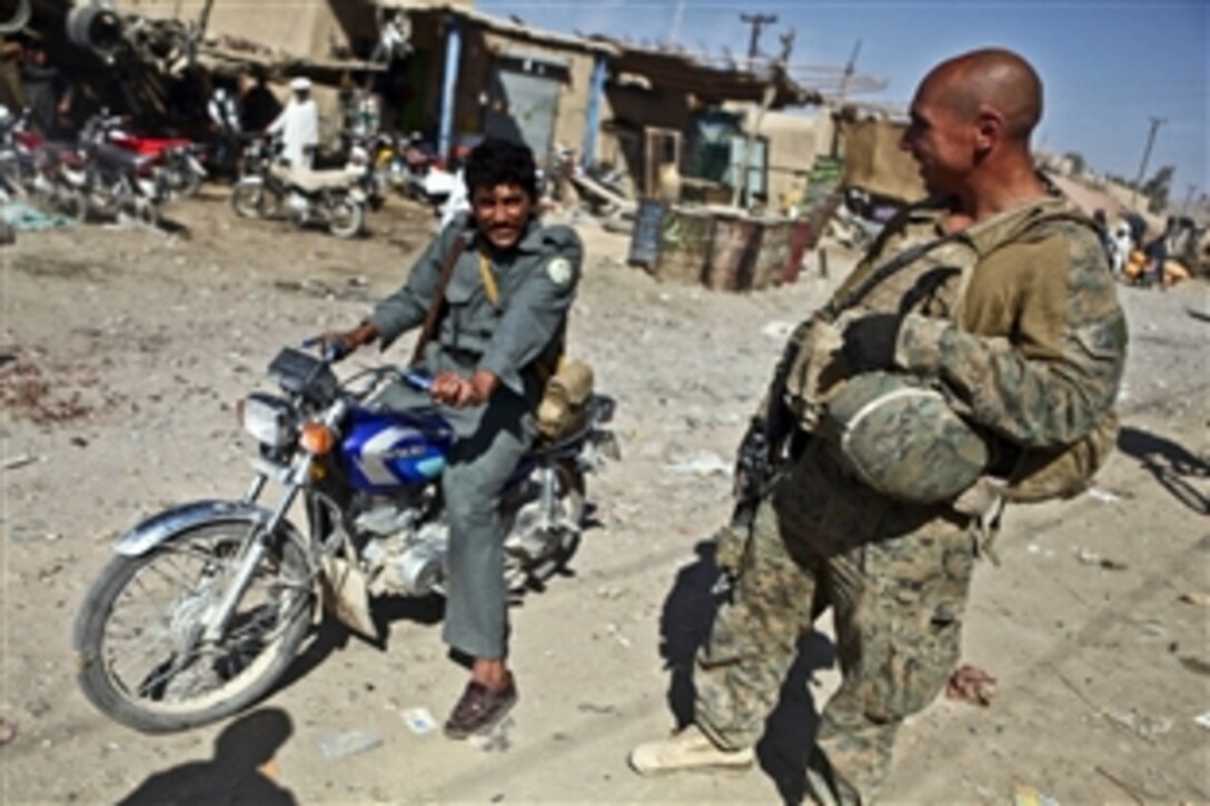 U.S. Marine Sgt. Chris Gonzalez speaks with a member of the Afghan police at the Kajaki Sofla Bazaar in Helmand province, Afghanistan, Nov. 5, 2011. Gonzalez is the civil affairs team chief assigned to Company B, 1st Battalion, 6th Marine Regiment. U.S. Marines assigned to the 1st Battalion, 6th Marine Regiment joined Afghan police in celebrating the Islamic holiday of Eid al-Adha, which encourages both reconciliation and charitable giving.