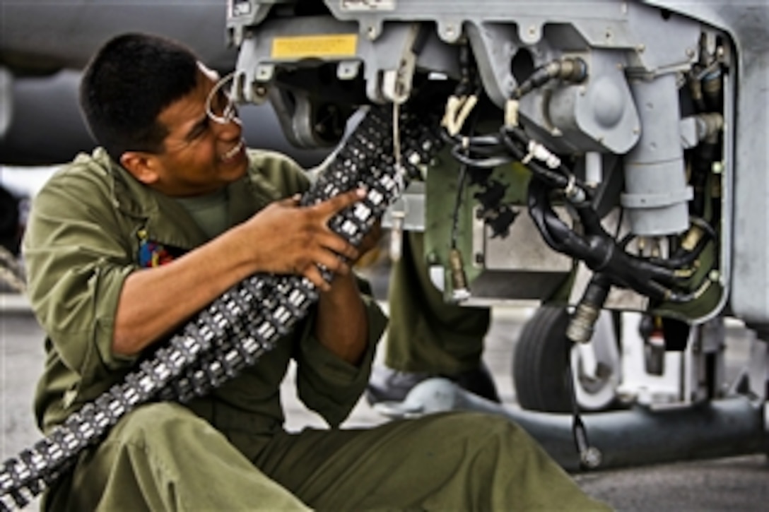 U.S. Marine Corps Cpl. Ceasar Vargas installs a linkless feed system into a AH-1Z Super Cobra helicopter aboard the USS Makin Island under way in the Pacific Ocean, Nov. 16, 2011. Vargas is an aviation ordnance man assigned to Marine Medium Helicopter Squadron 268.