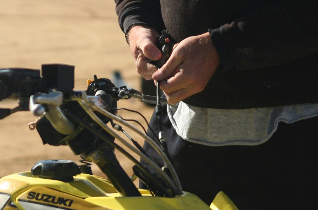 A Marine with the 2nd Marine Logistics Group fixes the brakes on an all terrain vehicle before the off-road quarterly ride at Busco Beach in Goldsboro, N.C., November 18, 2011. The intent of the training was to facilitate off-road training for Marines and sailors with the 2nd MLG. The training was given by more experienced riders who possessed the knowledge junior riders could benefit from. (U.S. Marine Corps photo by. Pfc. Franklin E. Mercado)