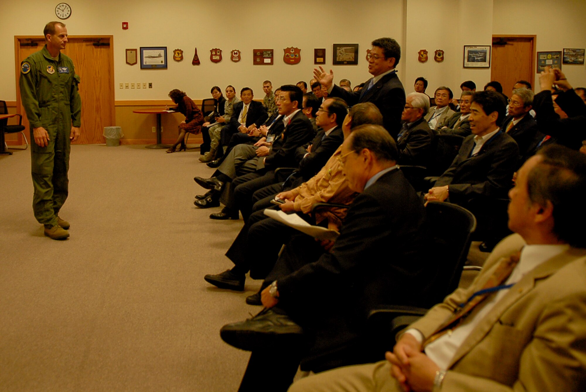 U.S. Air Force Col. Corey Martin, 18th Wing vice commander, takes time after an 18th Wing mission brief to answer questions from members of the Liaison Council of Defense-related Kyushu-Okinawa Prefectural and City Assemblies, a pro-United States group, before a tour of Kadena Air Base, Japan, Nov. 17, 2011. The brief and tour helped the group learn the role Kadena plays to the defense of Okinawa and further understand the importance of United States military presence. (U.S. Air Force photo by Airman 1st Class Tara A. Williamson/released)