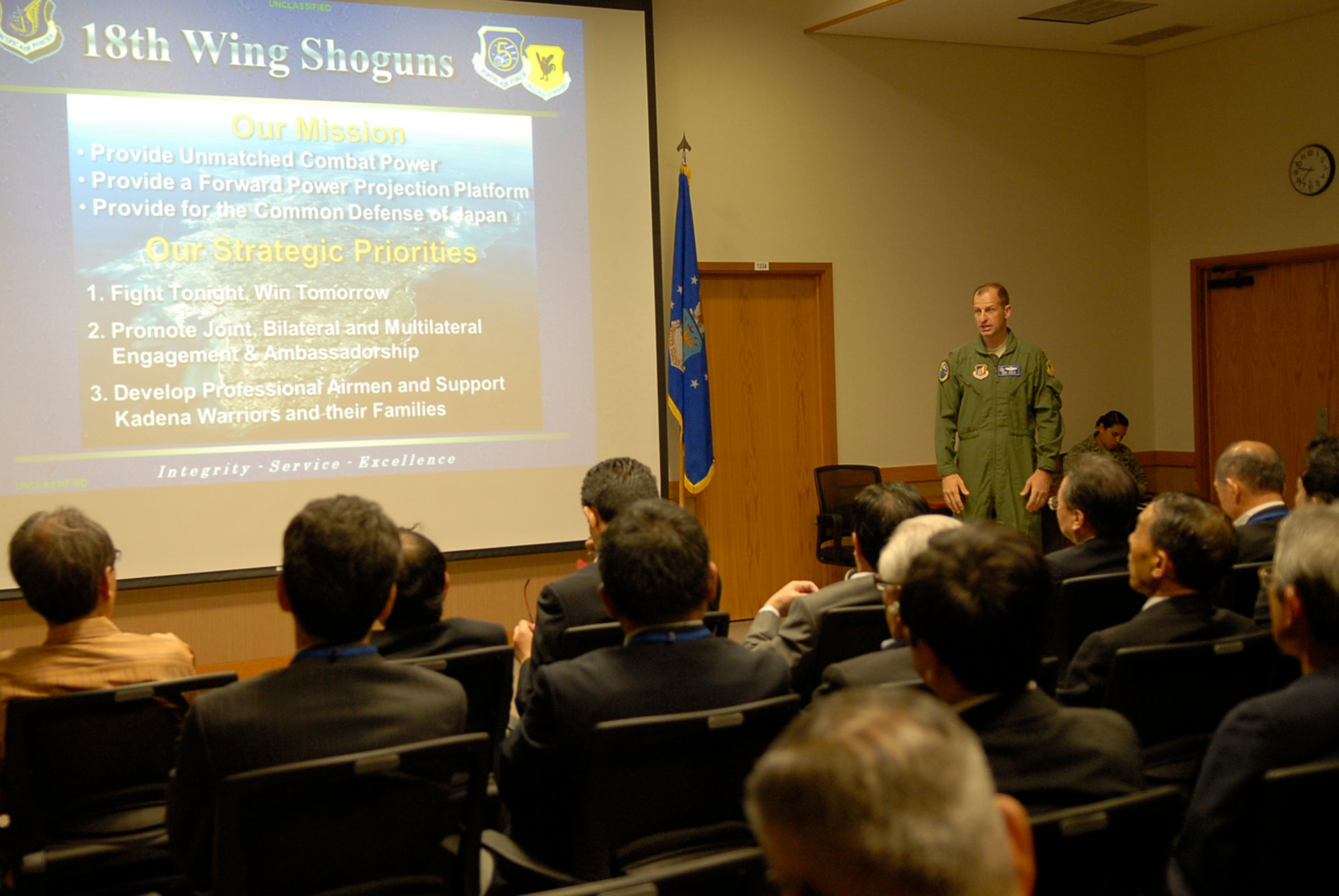U.S. Air Force Col. Corey Martin, 18th Wing vice commander, gives an 18th Wing mission brief to the Liaison Council of Defense-related Kyushu-Okinawa Prefectural and City Assemblies, a pro-United States group, on Kadena Air Base, Japan, Nov. 17, 2011. The brief, followed by a base tour, helped the group learn the role Kadena plays to the defense of Okinawa and further understand the importance of United States military presence. (U.S. Air Force photo by Airman 1st Class Tara A. Williamson/released)