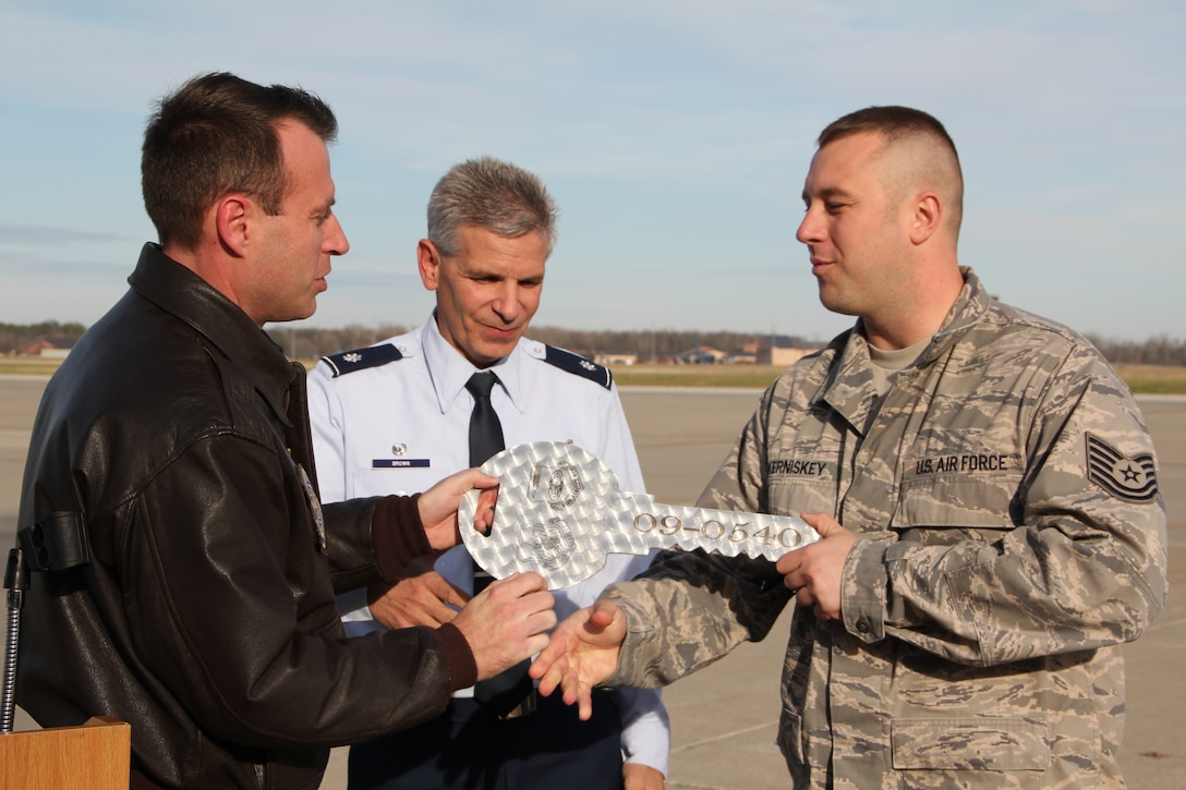 Lt. Cols. Dennis Veeneman (from left) and Paul Brown present Tech. Sgt.  Ryan Kerniskey the ceremonial key to Tail Number 0540.   Kerniskey is a C-40C flying crew chief who was part of the crew that brought the new C-40 to Scott AFB.  Veeneman and Brown piloted the aircraft. (U.S. Air Force photo/Tech. Sgt. Dan Oliver)