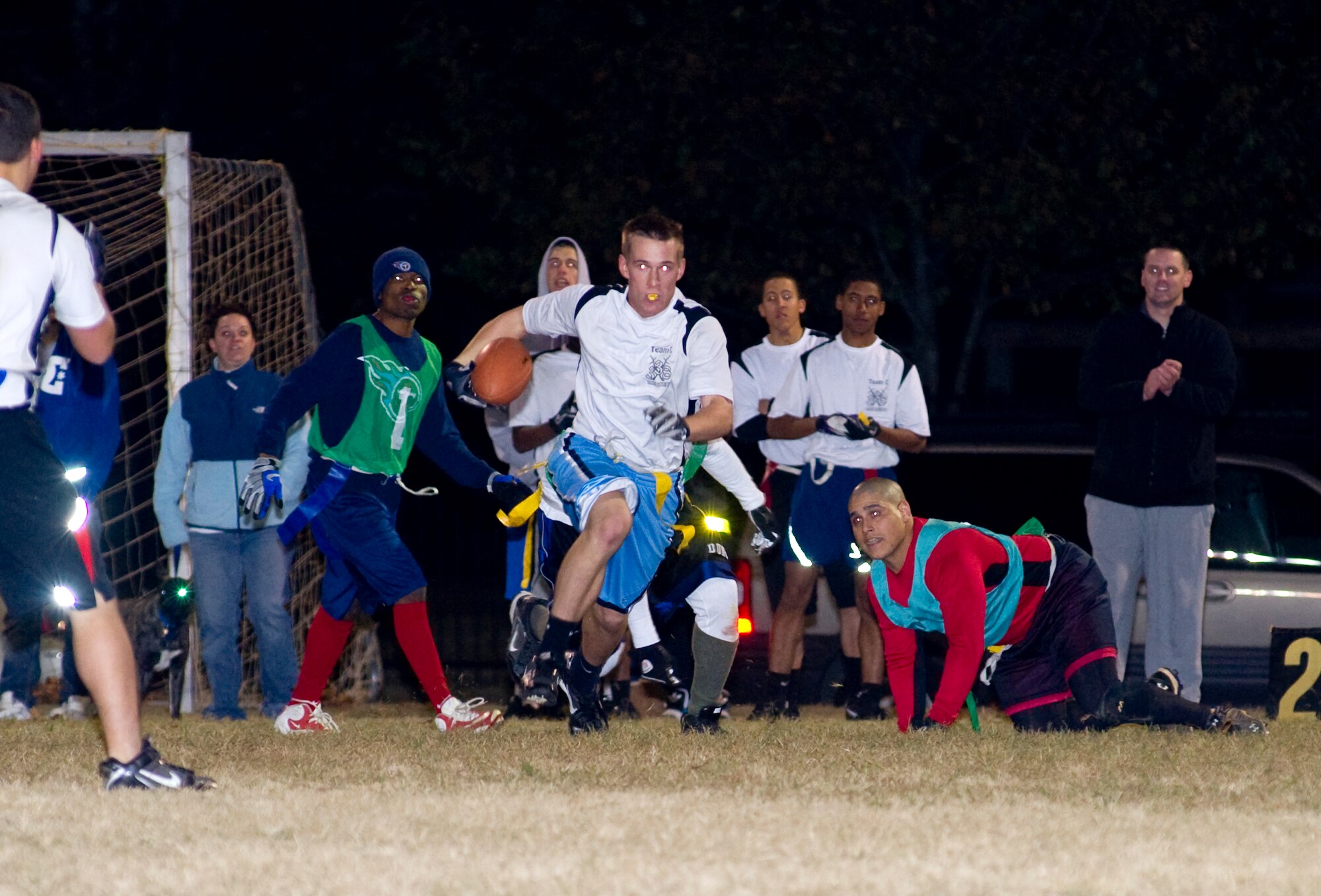 Timothy Hilton, 338th Training Squadron, gets past Trae Clark and Roberto Lugaro, 
temporarily breaking through the 334th Training Squadron's defense.  The Dark Knights defeated the Gators, 20-13.  (U.S. Air Force photo by Adam Bond)