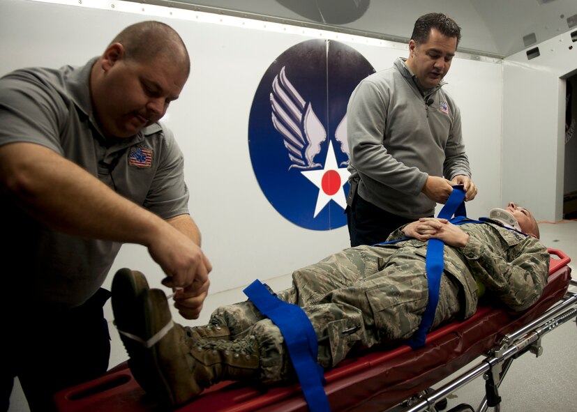 Scott McIntyre and Joseph McCluan, firefighters, paramedics and S.A.F.E (Stay Alive From Education) program directors, demonstrate on U.S. Air Force Airman 1st Class Joshua Castellar, 23rd Logistics Readiness Squadron, the painful medical procedures they conduct when someone sustains traumatic injuries at Moody Air Force Base, Ga., Nov. 18, 2011. McIntyre and McClaun traveled from Orlando, Fla., to share their stories and educated Moody on the consequences of driving while intoxicated and not wearing a safety belt. (U.S. Air Force photo by Senior Airman Eileen Meier/Released)