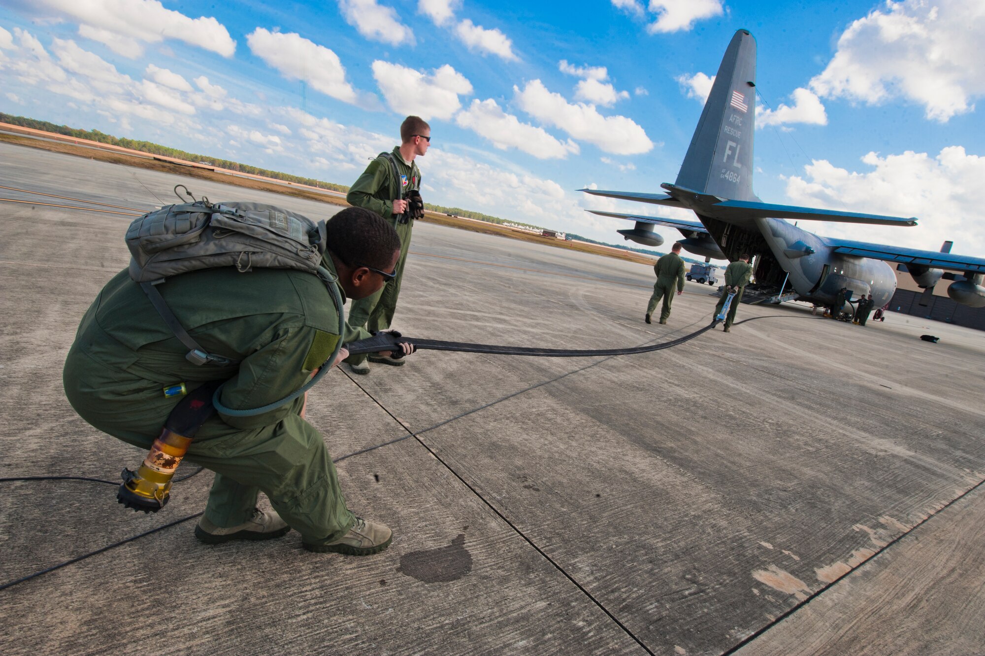 U.S. Air Force Master Sgt. Quetonius Jenkins, 23rd Logistic Readiness Squadron, extends a fuel line hose as Senior Airman Mark Theobald, 39th Rescue Squadron based out of Patrick Air Force Base, Fla., squeegees the hose to remove remaining fuel during a forward area refueling point training drill on Moody Air Force Base, Ga., Nov. 15, 2011. The two members worked as a team to ensure there was little to no aircraft fuel left in the hose prior to rolling it up. (U.S. Air Force photos by Staff Sgt. Joshua J. Garcia/Released) 