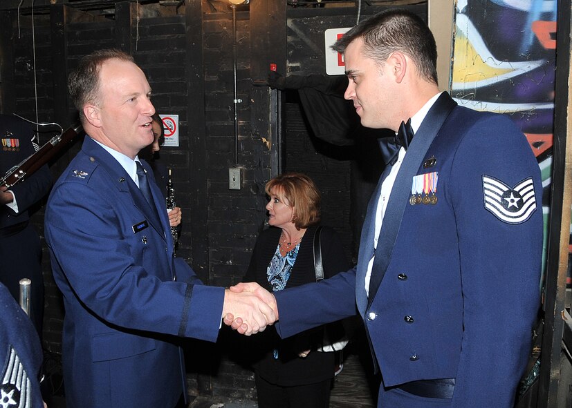 Col. David Hornyak, 377th Air Base Wing vice commander, left, hands a Commander’s Coin to Tech. Sgt. Gerald Welker, Academy Winds performer. The band performed Nov. 12 at the Historic El Rey Theater to an audience of approximately 400.
