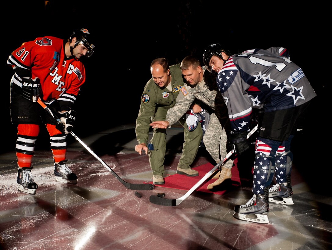 Maj. Gen. Timothy Reisch, South Dakota Air and Army National Guard commanding General, and Col. John Nichols, 28th Operations Group commander, drop ceremonial hockey pucks to kick off the Rapid City Rush Military Appreciation Night in honor of Veterans Day at the Rushmore Plaza Civic Center in Rapid City, S.D., Nov. 11, 2011. Retired and active duty military members were invited to the hockey game to honor and thank them for their service to the United States military. (U.S. Air Force photo by Airman 1st Class Kate Thornton/Released)