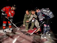 Maj. Gen. Timothy Reisch, South Dakota Air and Army National Guard commanding General, and Col. John Nichols, 28th Operations Group commander, drop ceremonial hockey pucks to kick off the Rapid City Rush Military Appreciation Night in honor of Veterans Day at the Rushmore Plaza Civic Center in Rapid City, S.D., Nov. 11, 2011. Retired and active duty military members were invited to the hockey game to honor and thank them for their service to the United States military. (U.S. Air Force photo by Airman 1st Class Kate Thornton/Released)