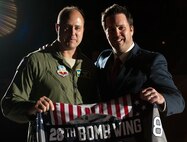 Col. John Nichols, 28th Operations Group commander, and Tim Hill, Rapid City Rush general manager, hold a patriotic themed hockey jersey before the Rapid City Rush hockey game at the Rushmore Plaza Civic Center in Rapid City, S.D., Nov. 11, 2011. Col. Nichols accepted the jersey on behalf of Ellsworth Air Force Base during the Rush hockey team’s Veterans Day military appreciation game as a token of gratitude to those who have served and currently serve in the Unites States military.  (U.S. Air Force photo by Airman 1st Class Kate Thornton/Released) 
